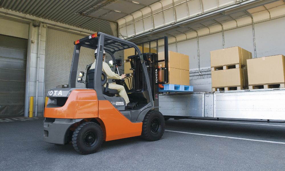 Engine-powered Toyota forklift model 8FG25 loading a lorry cargo space from the side