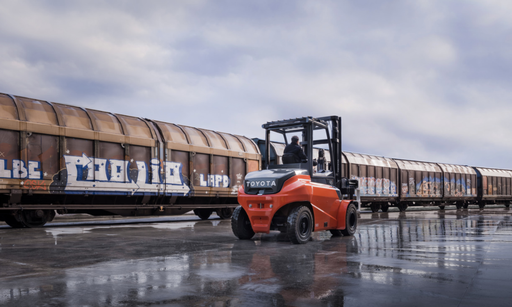 Toyota forklift 9FBM70T outside driving next to a cargo train