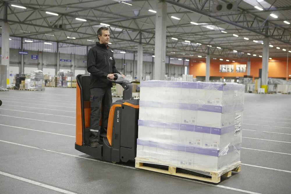 BT Levio powered pallet truck, electric low-lifter with backrest option. Application photo in a warehouse environment. 