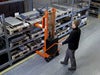 Toyota Lifter SHL080 hand pallet truck, electric stacker with forks raised. Application photo in a manufacturing environment. 
