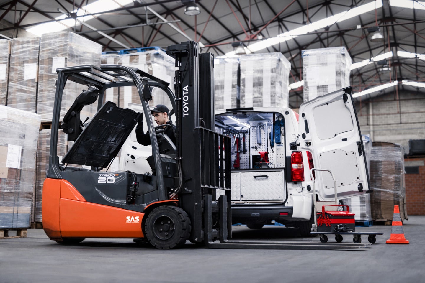 Toyota service technician servicing an electric three-wheeled forklift inside a warehouse