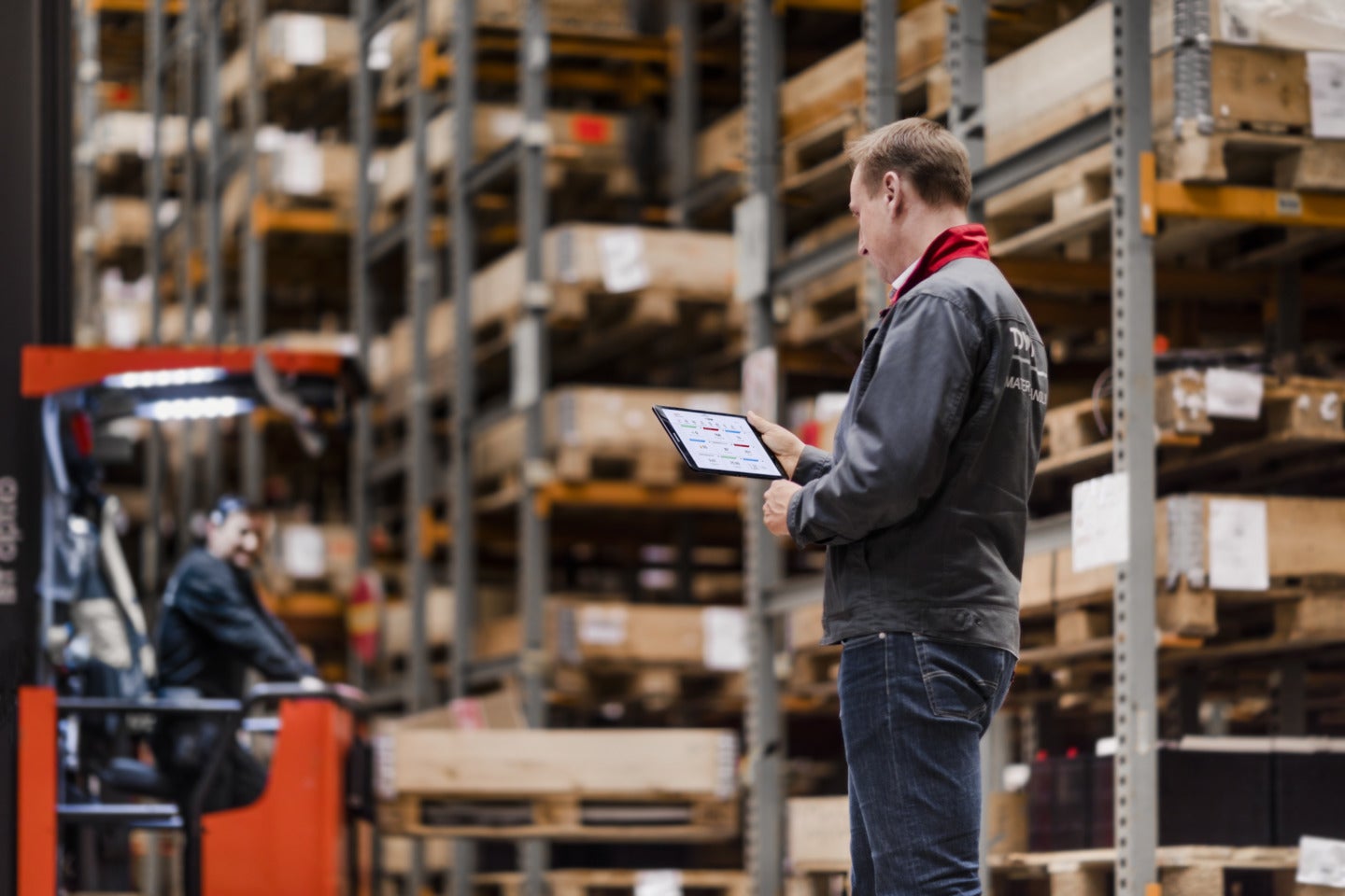 Employee in warehouse surveying data from the I_site application on a tablet