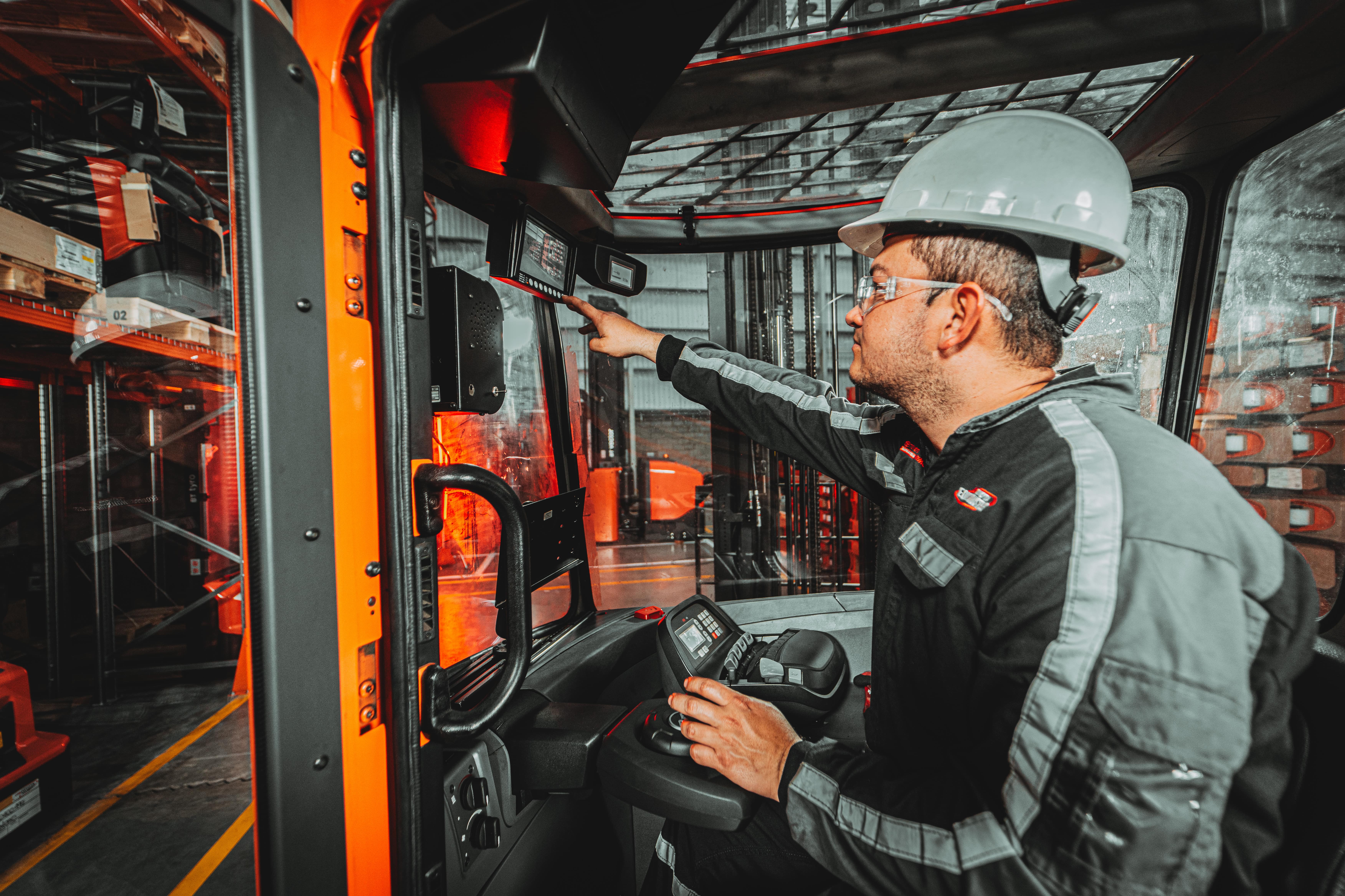 Application photograph of operator inside forklift checking back camera on screen. Attribution to Distoyota, Colombia. 