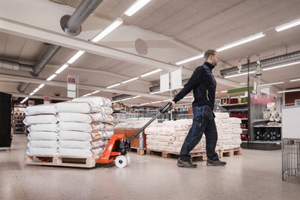 Man moving a pallet inside a store with a Toyota hand pallet truck